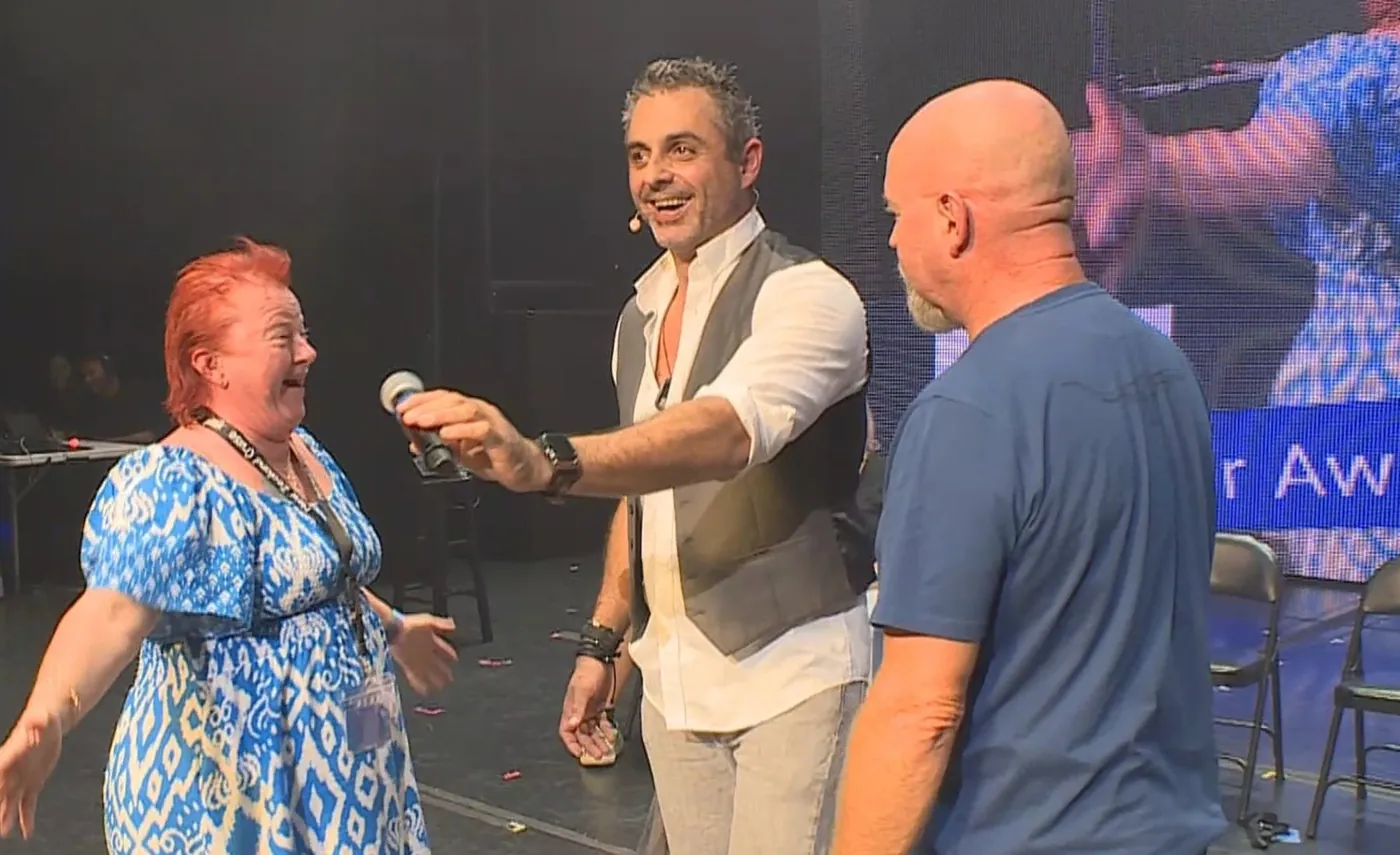 A row of volunteers on stage reacting all at once during the comedy hypnosis show