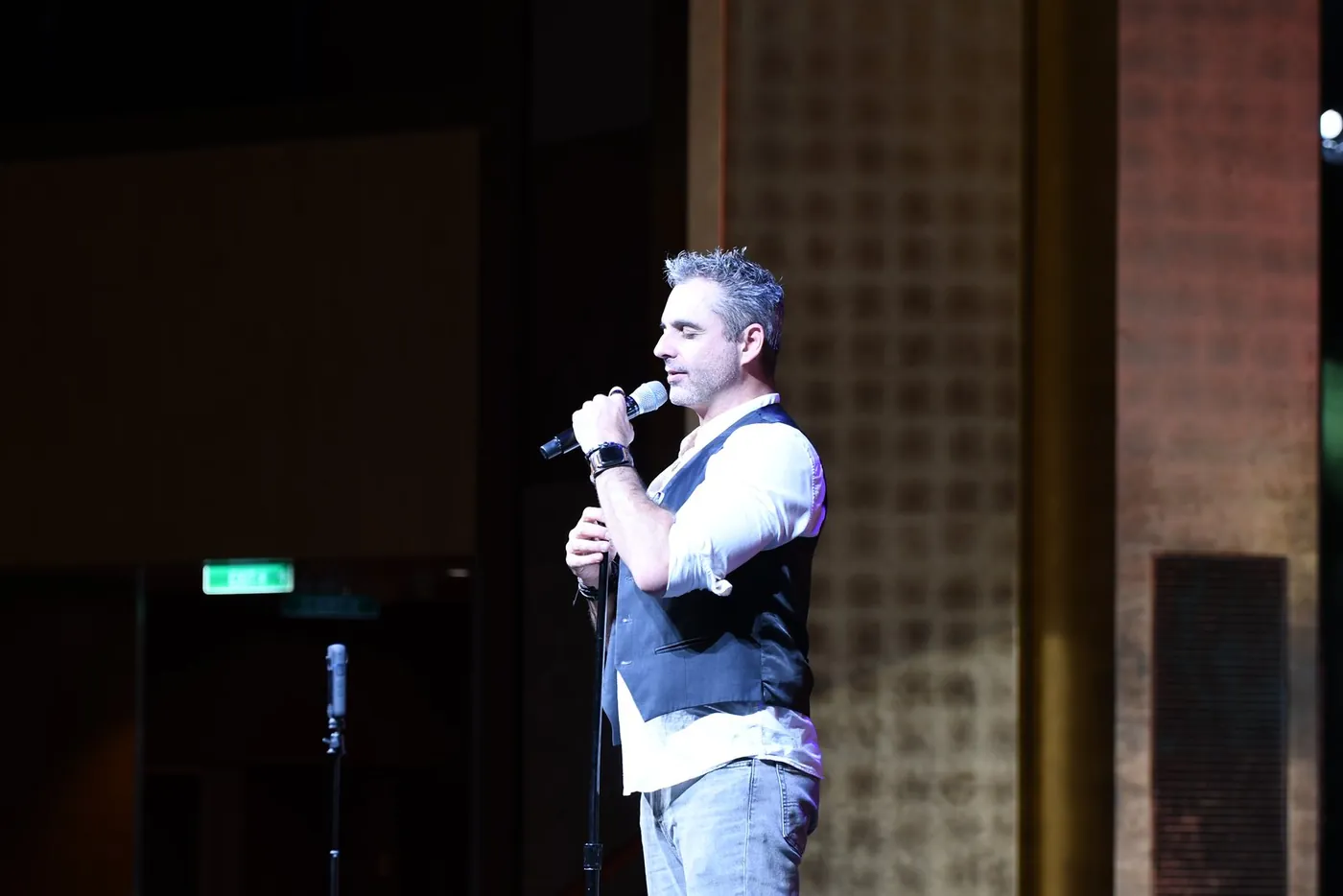 Phoenix on stage with a microphone during the comedy hypnosis show